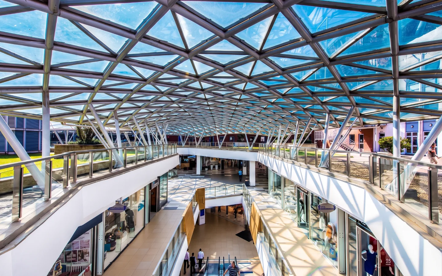 Glass-canopied retail walkway inside Melrose Arch